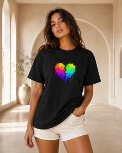 Woman wearing a black t-shirt with a colorful heart design in a bright room.