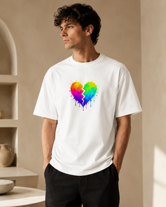 Person wearing a white t-shirt with a colorful heart design in a neutral setting
