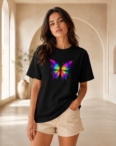 Woman wearing a black t-shirt with a colorful butterfly design in a bright room.
