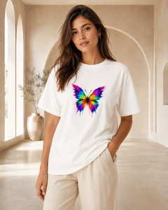Woman wearing a white t-shirt with a colorful butterfly design in a bright room.
