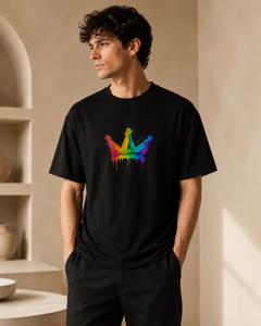 Man wearing a black t-shirt with a colorful crown design in a neutral setting