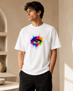 Man wearing a white t-shirt with a colorful eye design in a neutral setting