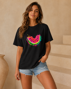 Woman wearing a black t-shirt with a colorful watermelon design in a neutral setting.