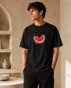 Man wearing a black t-shirt with a colorful watermelon design in a neutral setting
