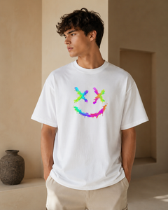 Person wearing a white t-shirt with a colorful smiley face design in a neutral setting.