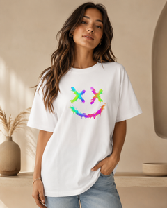 Woman wearing a white t-shirt with a colorful smiley face design in a neutral setting.