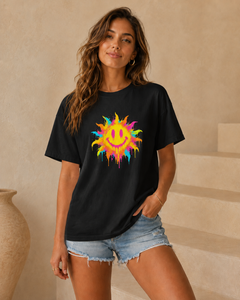 Woman wearing a black t-shirt with a colorful sun design in an indoor setting.