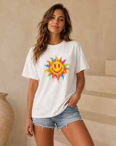 Woman wearing a white t-shirt with a colorful sun design in a neutral setting